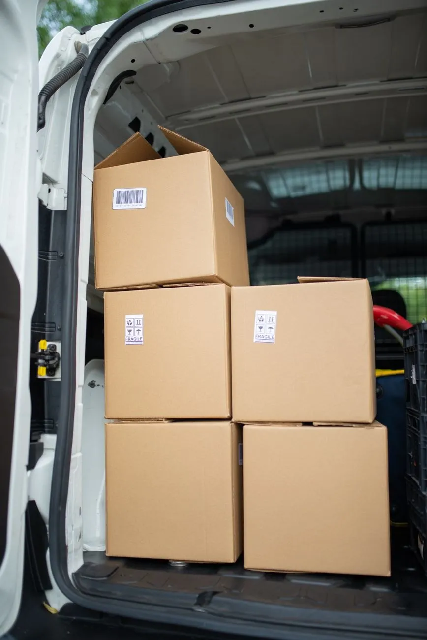 Plain boxes stacked in the back of a white van, ready to go